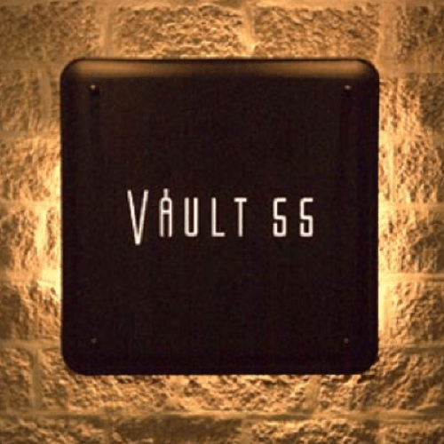 Vault 55 logo on a black metal sign mounted on a stone wall
